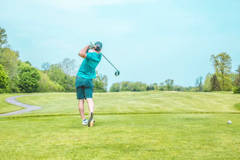 man playing gold under blue sky during daytime