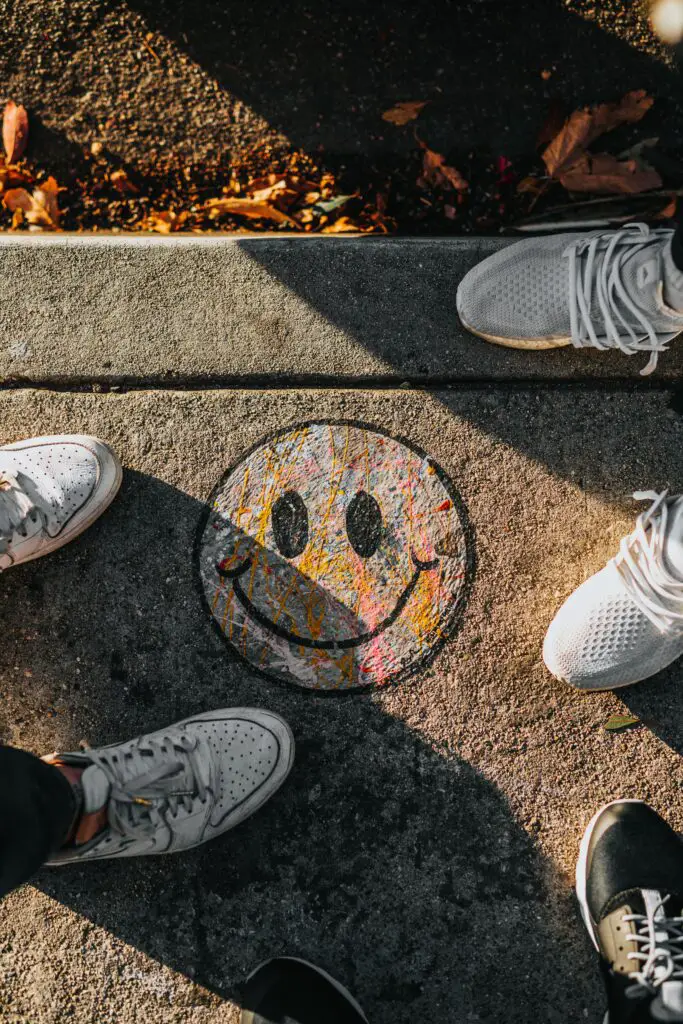 smiley paint on gray ground in front of people